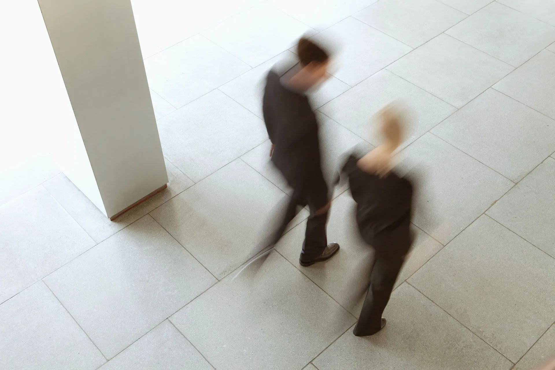 Sabah saatlerinde ofis lobisinden geçen çalışanlar (hareket bulanık)